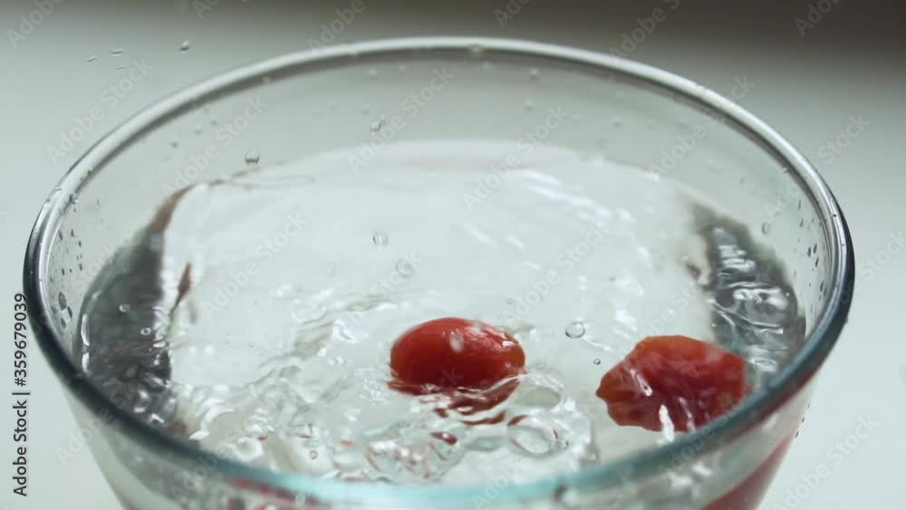 Tomatoes falls into the bowl with water in slow motion Tomatoes falls into the bowl with water in slow motion