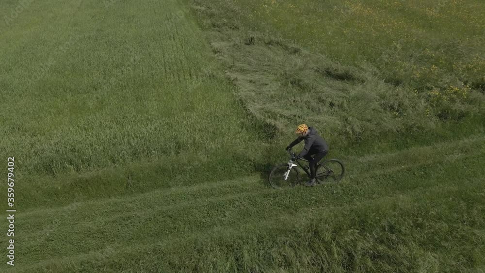 Aerial mountainbike women riding on bike in summer mountains meadow landscape. Woman cycling MTB flow trail track. Outdoor sport activity. Aerial mountainbike women riding on bike in summer mountains meadow landscape. Woman cycling MTB flow trail track. Outdoor sport activity.