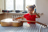 little girl holding a broken guitar, guitar repair