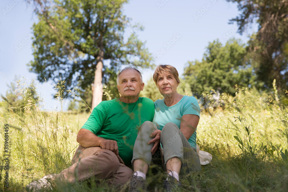 Portrait of attractive vibrant senior couple embracing in summer day outdoors. Staycations, hyper-local travel, family outing, getaway, natural environment Portrait of attractive vibrant senior couple embracing in summer day outdoors. Staycations, hyper-local travel, family outing, getaway, natural environment