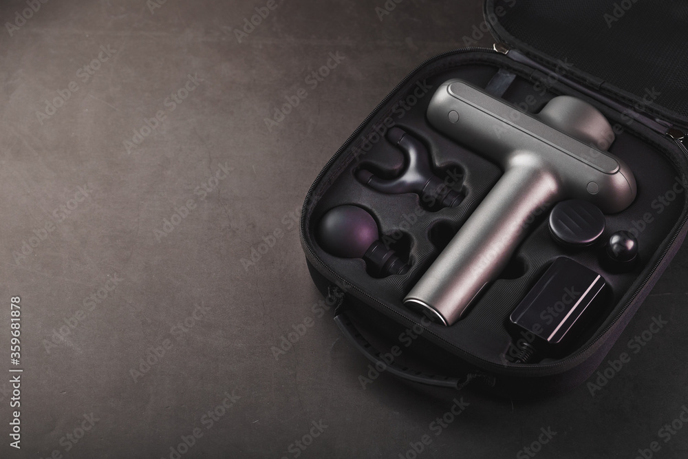 Electric massager Machine for body massage in a case on a black background. Electric massager Machine for body massage in a case on a black background.