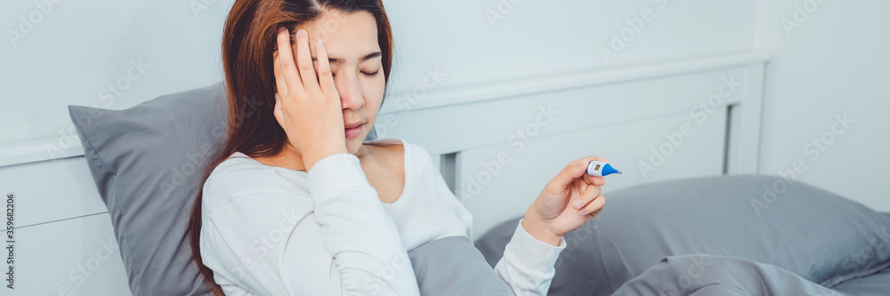 Asian woman flu and cold, feeling sick and using thermometer Checking fever . feeling sick health problems treatment concept Asian woman flu and cold, feeling sick and using thermometer Checking fever . feeling sick health problems treatment concept