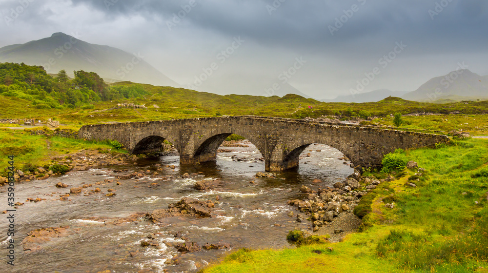 Sligachan bridge by the River Sligachan, on a overcast summers morning on the Isle of Skye, Scotland, with the Cuillin Mountains in the background.