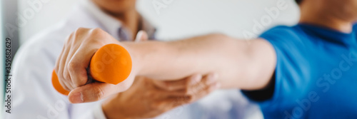 Foto Physiotherapist man giving exercise with dumbbell treatment About Arm and Should