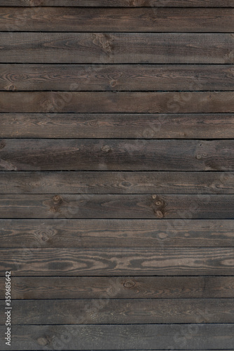 Wooden background. Old dark wooden surface. Wood planks. Coarse texture. Vertical frame