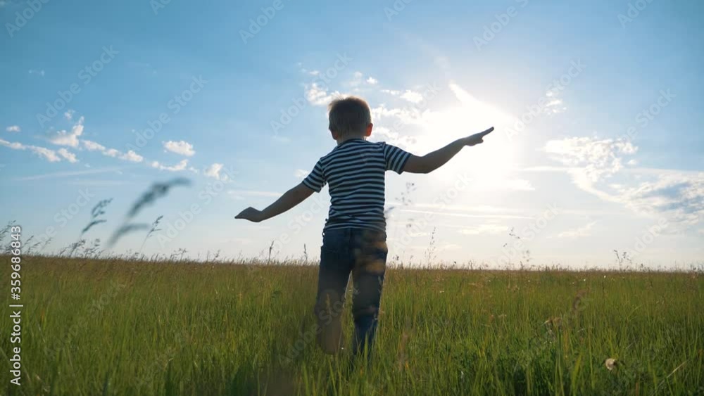A happy, lovely child runs through a green wheat field. The boy dreams of traveling by plane with his family. A happy childhood is a healthy way of life. A happy, lovely child runs through a green wheat field. The boy dreams of traveling by plane with his family. A happy childhood is a healthy way of life.