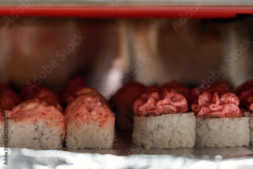 Rolls with mayonnaise caps are baked in the oven under hot heating elements photo