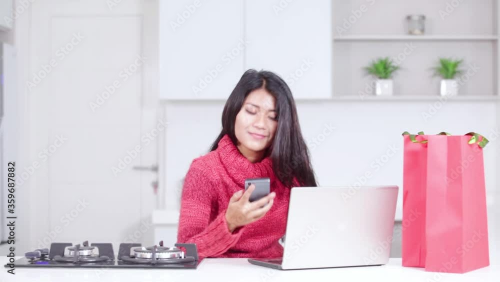 Woman using a cellphone and laptop to shopping Woman using a cellphone and laptop to shopping