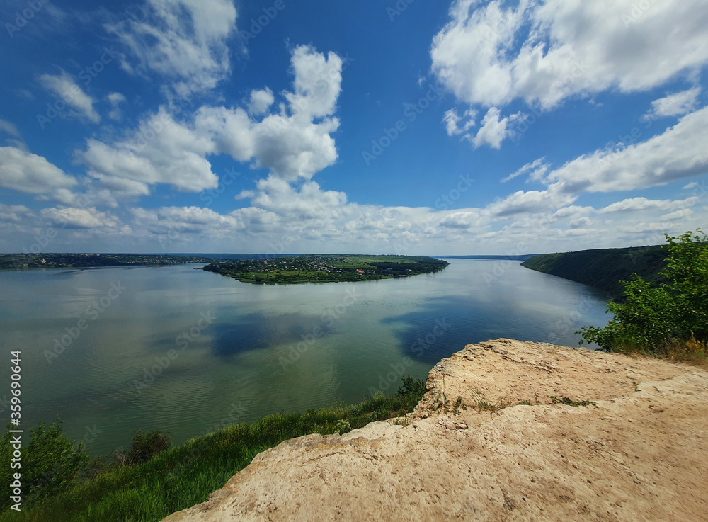 High angle, altitude view to the Nistru river, near Dubasari (Dubossary), Transnistria, Moldova. Idyllic panoramic scene on the peak of a cliff over the water under a rich blue sky.