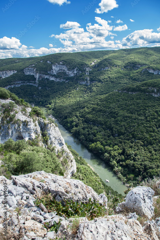 La rivière Ardèche coule au fond des gorges et des falaises calcaires La rivière Ardèche coule au fond des gorges et des falaises calcaires