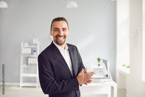 Happy businessman in formal suit standing in office