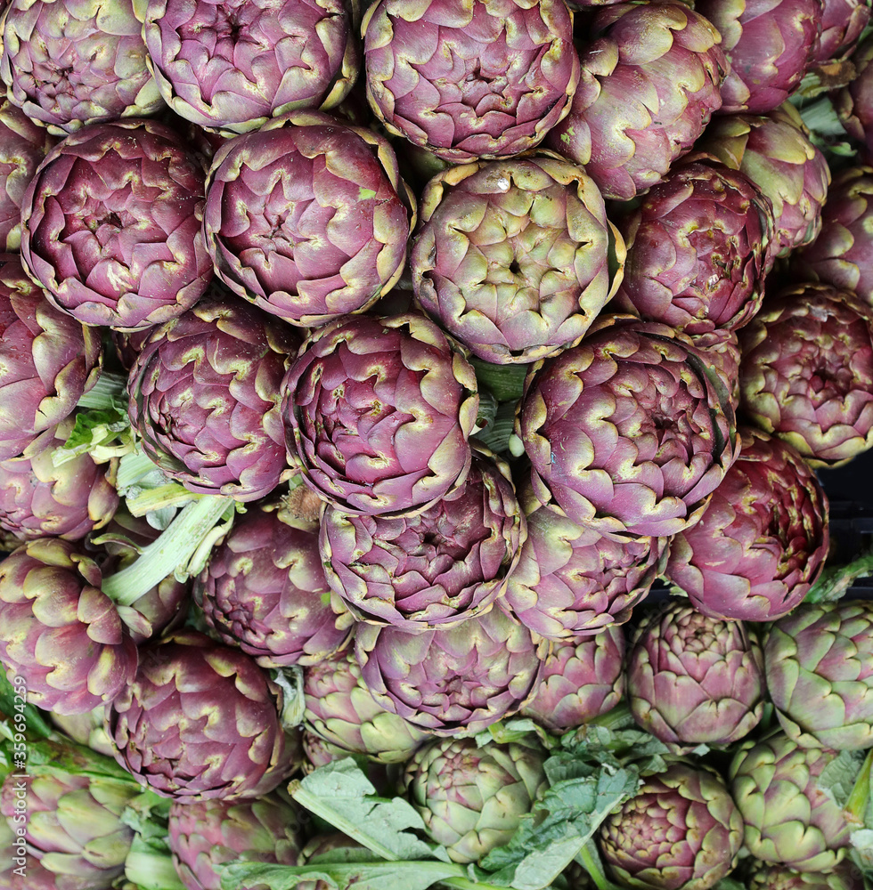 Fototapeta premium background of greens big green artichokes for sale in the vegeta
