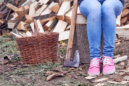 Woman carrying basket with cut woods prepared for winter.