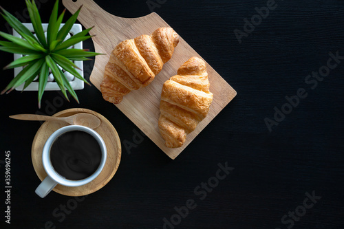 Картината върху платно flat lay two fresh croissants and cup of coffee on dark stone table