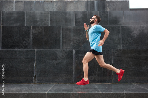 Modern sporty man jogging / exercise in urban environment. © astrosystem