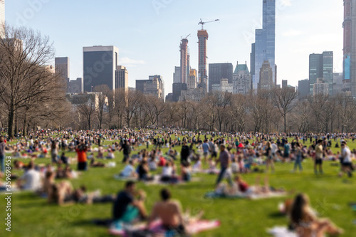 Obraz na płótnie Blurred crowds of people relaxing on the lawn in Central Park on a sunny day in New York City w salonie