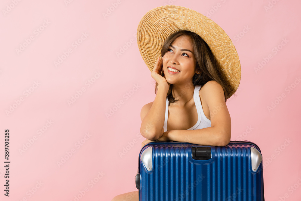 Asian woman wearing summer clothes standing with a suitcase Asian woman wearing summer clothes standing with a suitcase