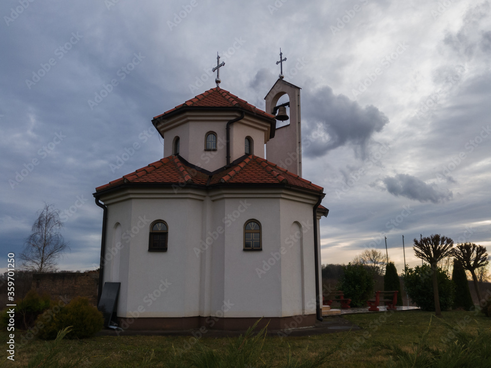Church in the countryside against overcast sky during evening.