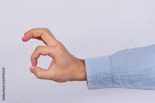 Male hand showing an ok sign with fingers. OK Gesture on white background.