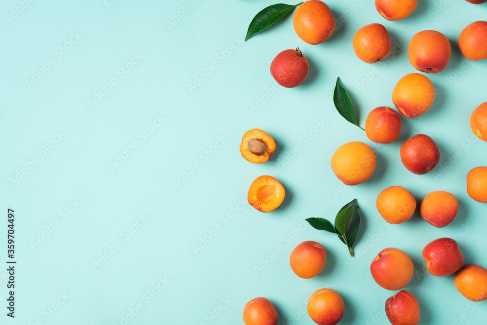 Apricot pattern on blue background. Top view, flat lay. Fresh summer fruit concept. Creative design. Healthy vegetarian food, detox or diet concept. Apricot pattern on blue background. Top view, flat lay. Fresh summer fruit concept. Creative design. Healthy vegetarian food, detox or diet concept.