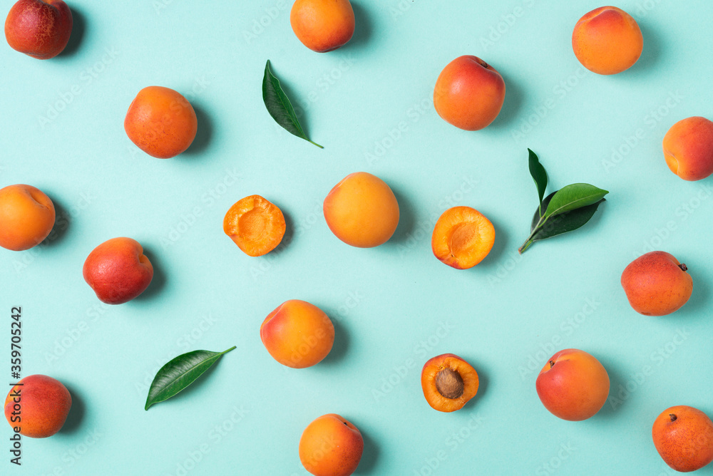Apricot pattern on blue background. Top view, flat lay. Fresh summer fruit concept. Creative design. Healthy vegetarian food, detox or diet concept. Apricot pattern on blue background. Top view, flat lay. Fresh summer fruit concept. Creative design. Healthy vegetarian food, detox or diet concept.