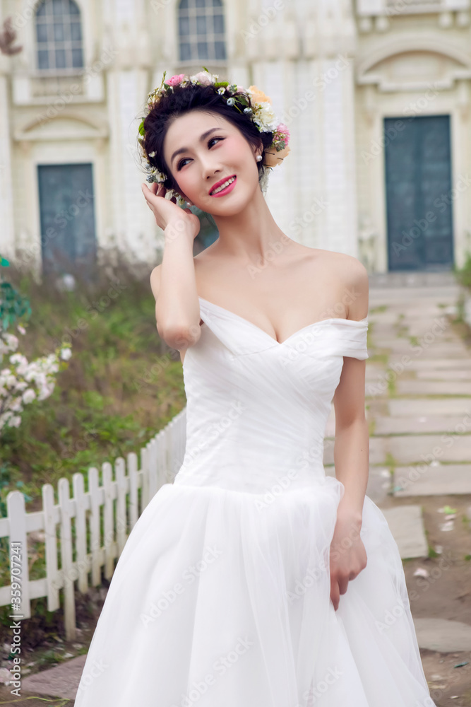 Asian bride in white wedding dress in the park