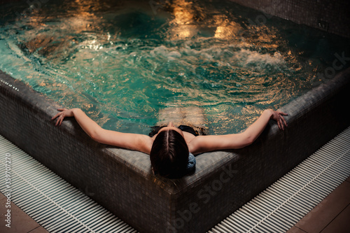 Conception of bodycare. Beauty and body care. View of a young woman enjoying whirlpool bath. Sensual young woman relaxing in spa hot tub.