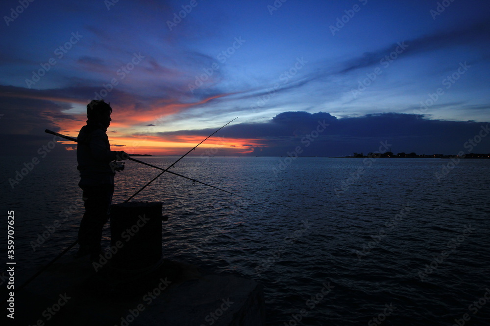 The silhouette of fishing at sunset