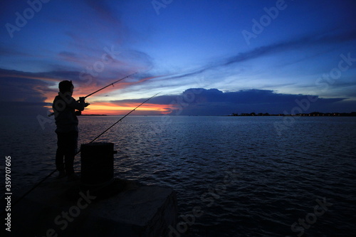 The silhouette of fishing at sunset