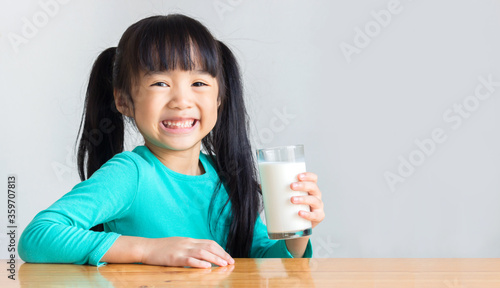 asian child take a glass of milk and smile happily 