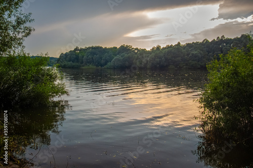 fishing spot on the lake for catching crucian carp, landscape of the lake before sunset on a cloudy evening