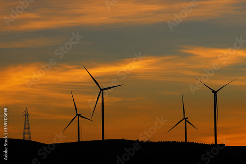 Wind turbines generating electricity with twilight sky - energy conservation concept