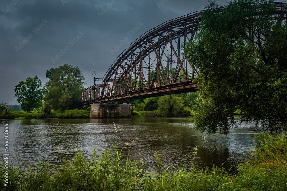 Fototapeta premium Railway bridge over the river on a cloudy day.