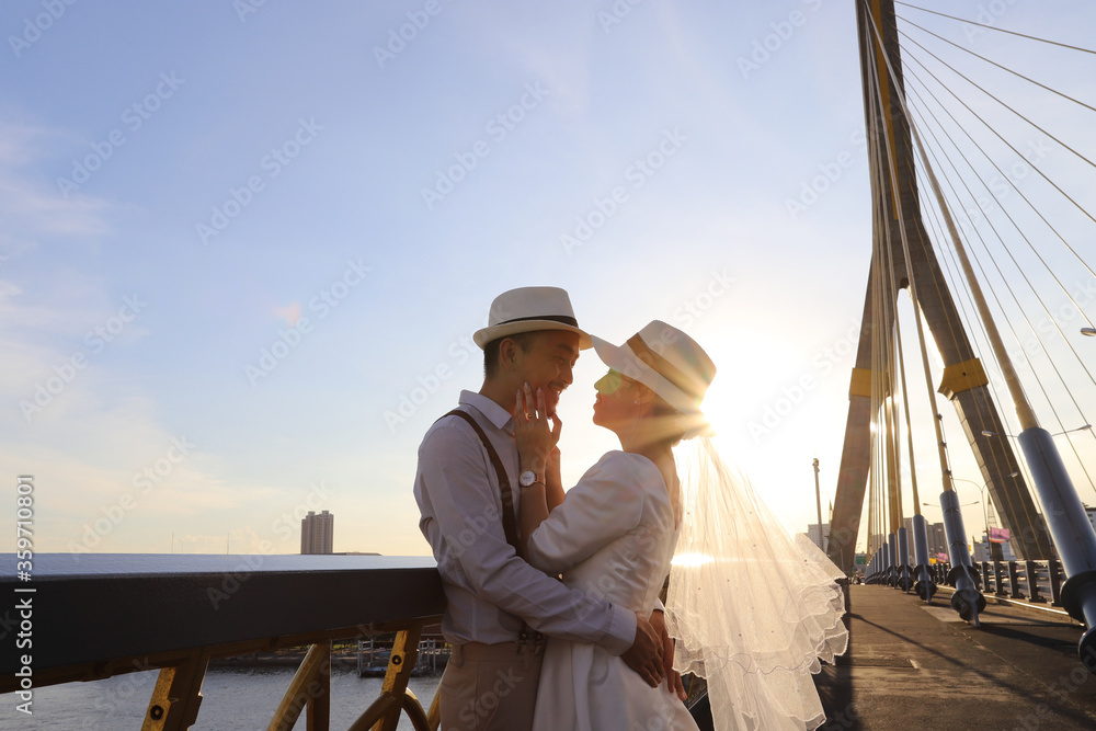 Wedding portrait of Asian couple hug together with beautiful sunlight in the evening