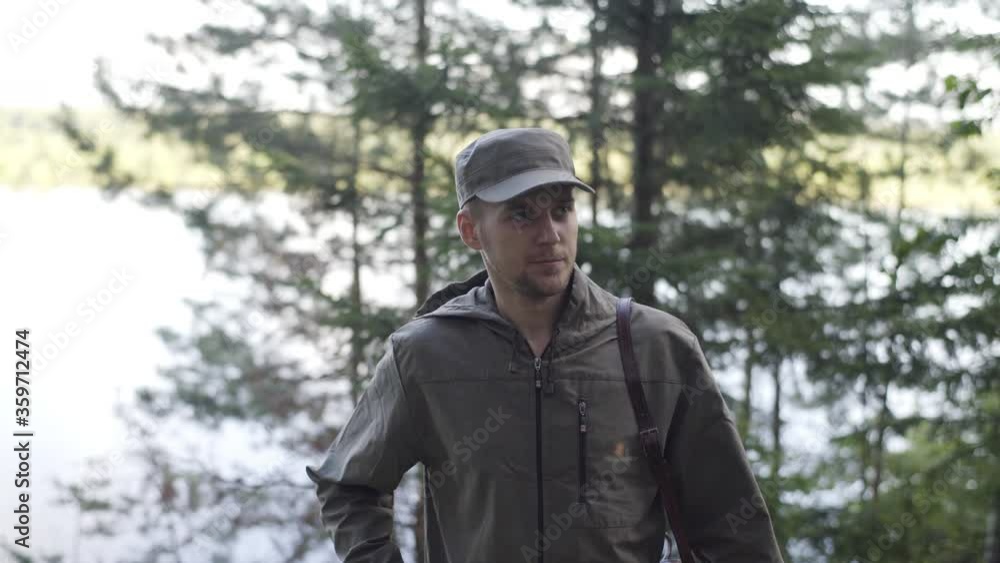 Portrait of Young Smiling Man Standing in Forest. Traveling Concept People in Nature. One Person Tourist Looking at Camera On the Background of Landscape Closeup. Hiker Journey in Wildlife Portrait of Young Smiling Man Standing in Forest. Traveling Concept People in Nature. One Person Tourist Looking at Camera On the Background of Landscape Closeup. Hiker Journey in Wildlife