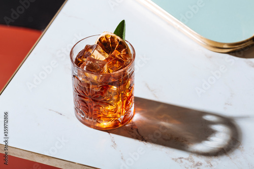 Quadro su tela Negroni cocktail  with dried orange slices and sage.