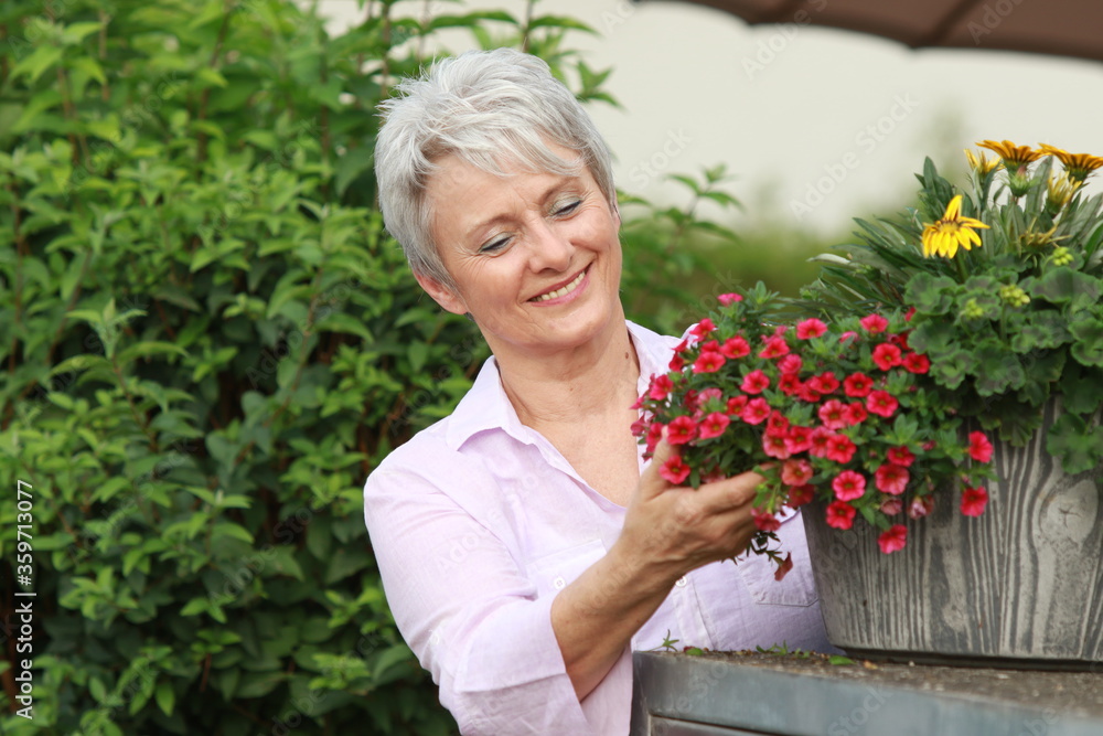 Senior woman with red flowers Senior woman with red flowers