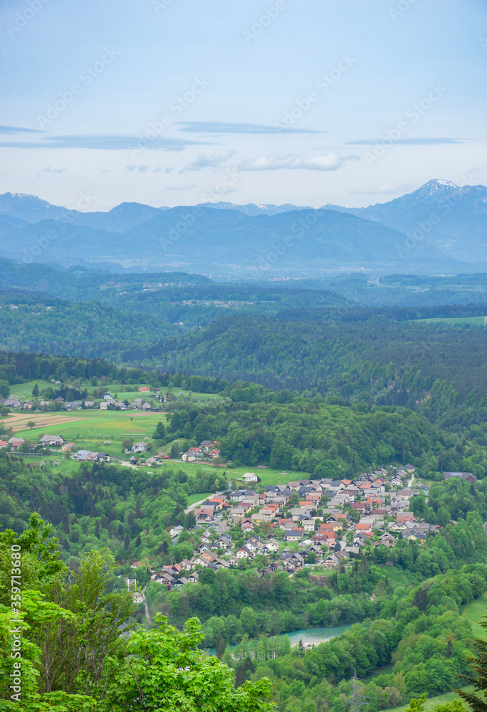 Slovenian countryside in spring with charming little village and Julian Alps in the background