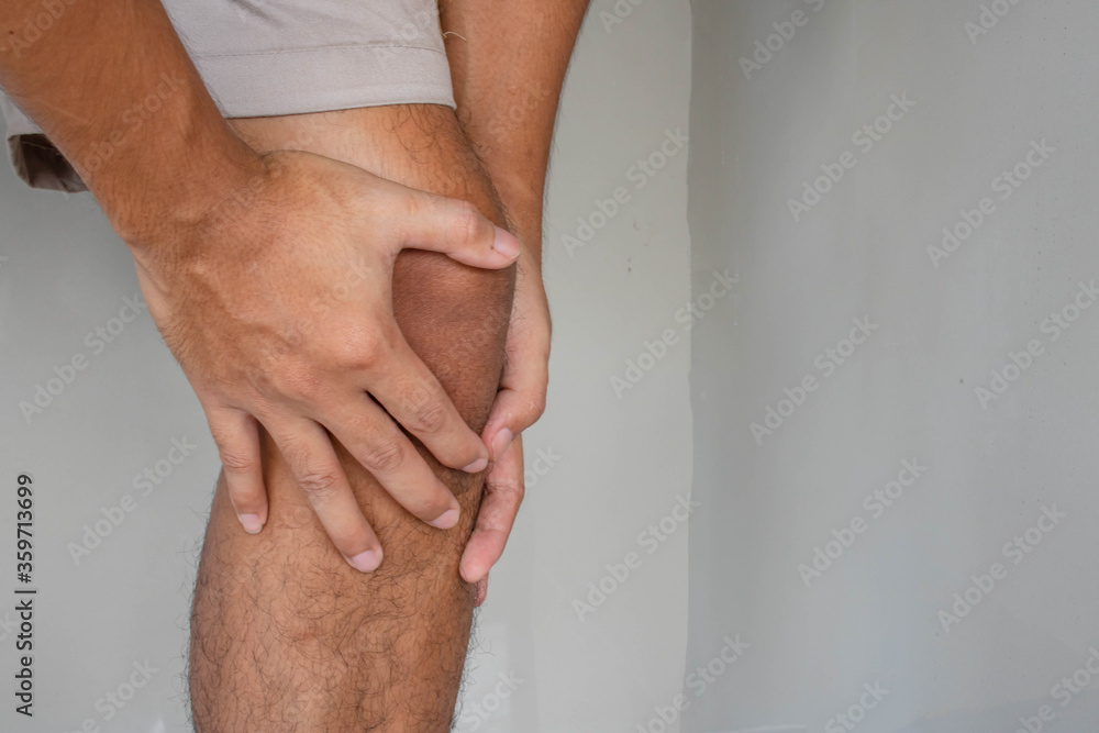 Man holds on to knee, pain in knee. People with knee pain and feeling bad hand on he knee, healthy concept.