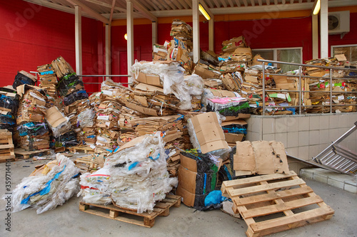 A large pile of cardboard boxes from the goods sold, stored in the back of the supermarket. The concept of urban pollution