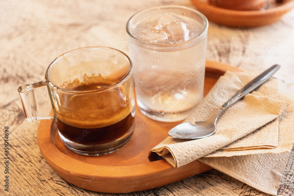 Espresso coffee in glass cup on wooden tray Espresso coffee in glass cup on wooden tray