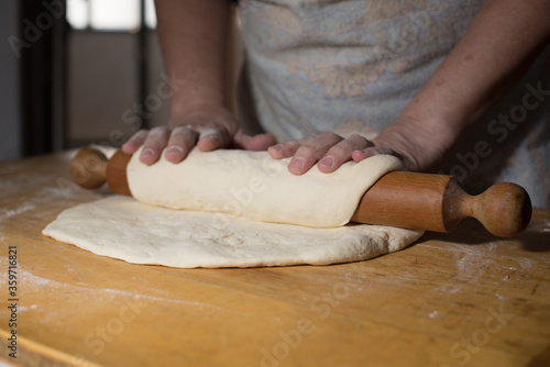 preparing dough with roler and hands