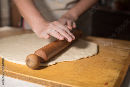 preparing dough for baking with hands and roler 