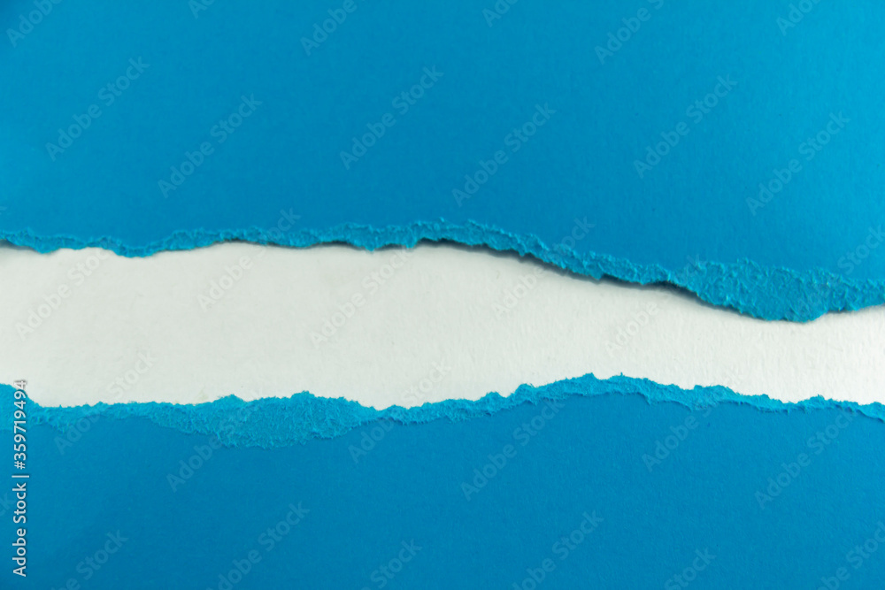 divided halves of the sheet of blue ripped paper on white background divided halves of the sheet of blue ripped paper on white background