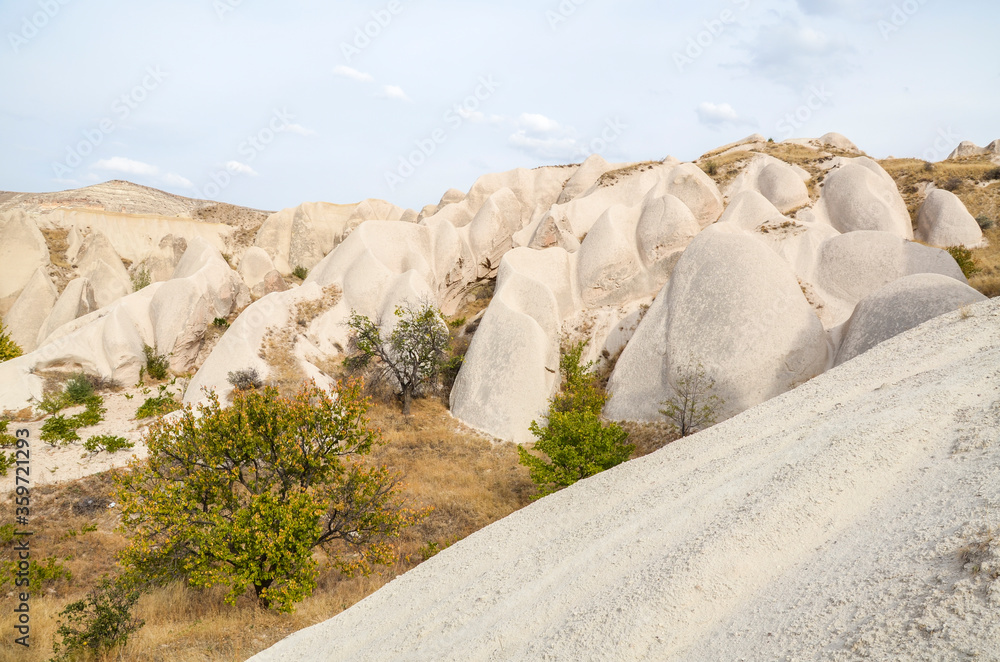 Beautiful landscape of ancient eroded white and pink sandstone rock formations in Cappadocia valley, Turkey