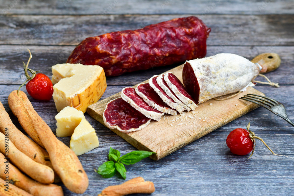 Italian artisan dred salami. parmesan cheese and sausage on wooden board Italian artisan dred salami. parmesan cheese and sausage on wooden board