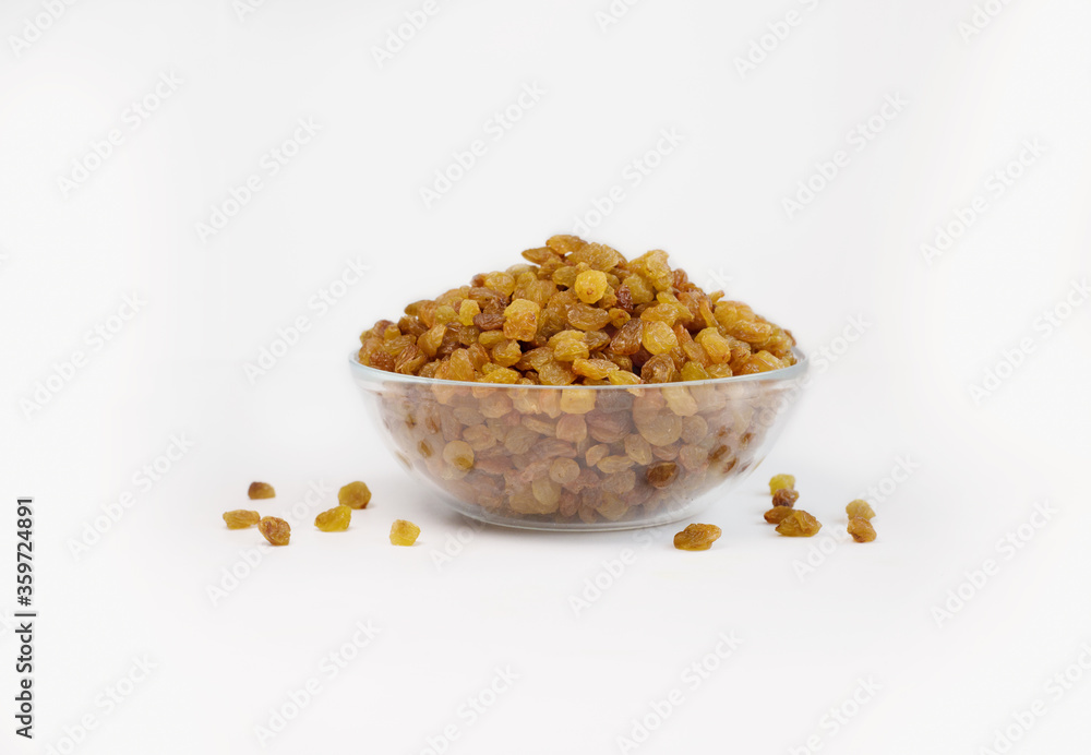 light brown raisins in a transparent bowl on a white background, side view light brown raisins in a transparent bowl on a white background, side view
