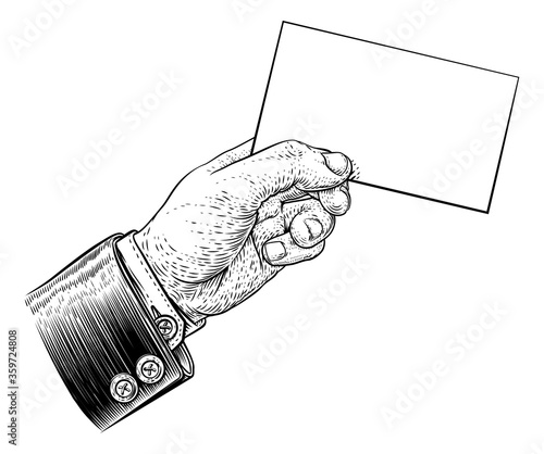 A hand in a suit holding a business card, letter, message, flyer or similar with copyspace. In a vintage engraved or etched woodcut print style