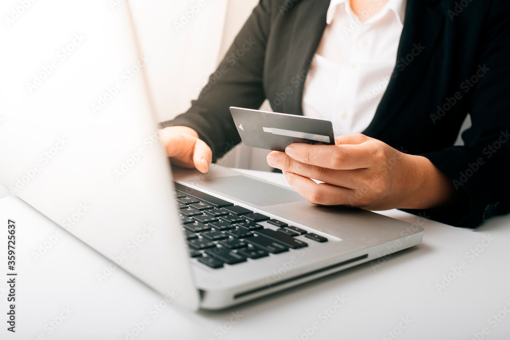 businesswoman hand using smart phone, tablet payments and holding credit card online shopping, omni channel, digital tablet docking keyboard computer at office in sun light businesswoman hand using smart phone, tablet payments and holding credit card online shopping, omni channel, digital tablet docking keyboard computer at office in sun light
