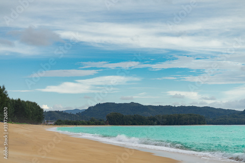 sand sea beach with pine tree and mountain, blue sky background